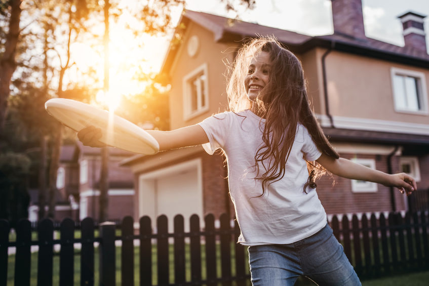 Girl playing at garden fence